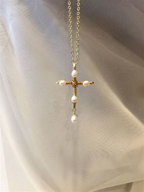 Experience the Timeless Sophistication of a Petite Gilded Cross Pendant