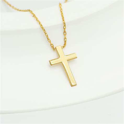 The Significance of a Tiny Gilded Cross Necklace Charm